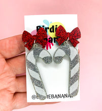 Load image into Gallery viewer, soarkly silver glitter chriatmas candy cane earrings topped with a red glitter bow

